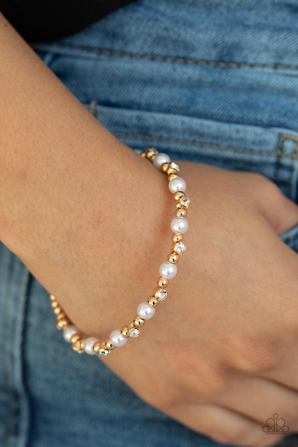 Paparazzi Accessories Decadently Dainty -Gold A collection of shiny gold beads, white pearls, and dainty white rhinestones are threaded along a dainty wire around the wrist for a timeless look. Sold as one individual bracelet. Jewelry
