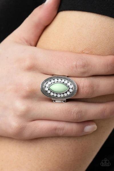Paparazzi Accessories Tea Light Twinkle ~Green A silver frame embellished with dewy white beads and studded silver texture creates a stunning backdrop for a Green Ash marquise cut bead as it sits atop the finger. Features a stretchy band for a flexible fi