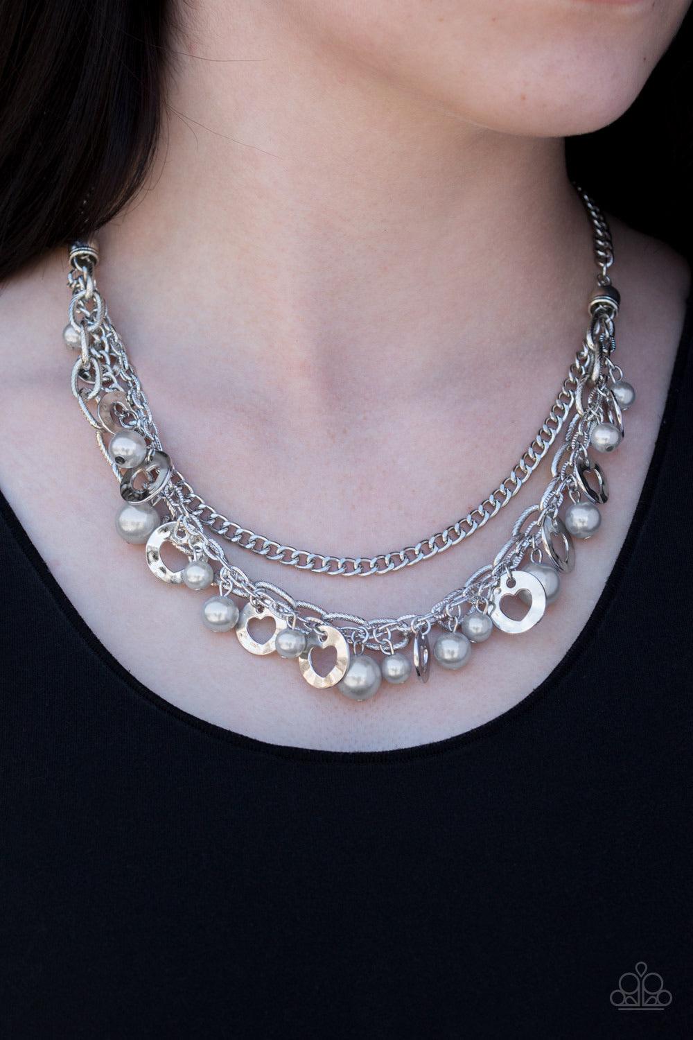 Paparazzi Accessories Hoppin Hearts - Silver Three rows of mismatched silver chains layer below the collar. Infused with airy heart cut-out centers, delicately hammered silver discs and pearly silver beads swing from the bottom of the lowermost chain, cre