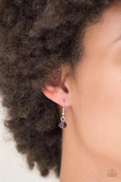 Paparazzi Accessories Socialite of the Season - Purple A glittery purple crystal-like bead swings from the bottom of a lengthened silver chain, giving way to a shimmering silver tassel for a glamorous finish. Features an adjustable clasp closure. Sold as