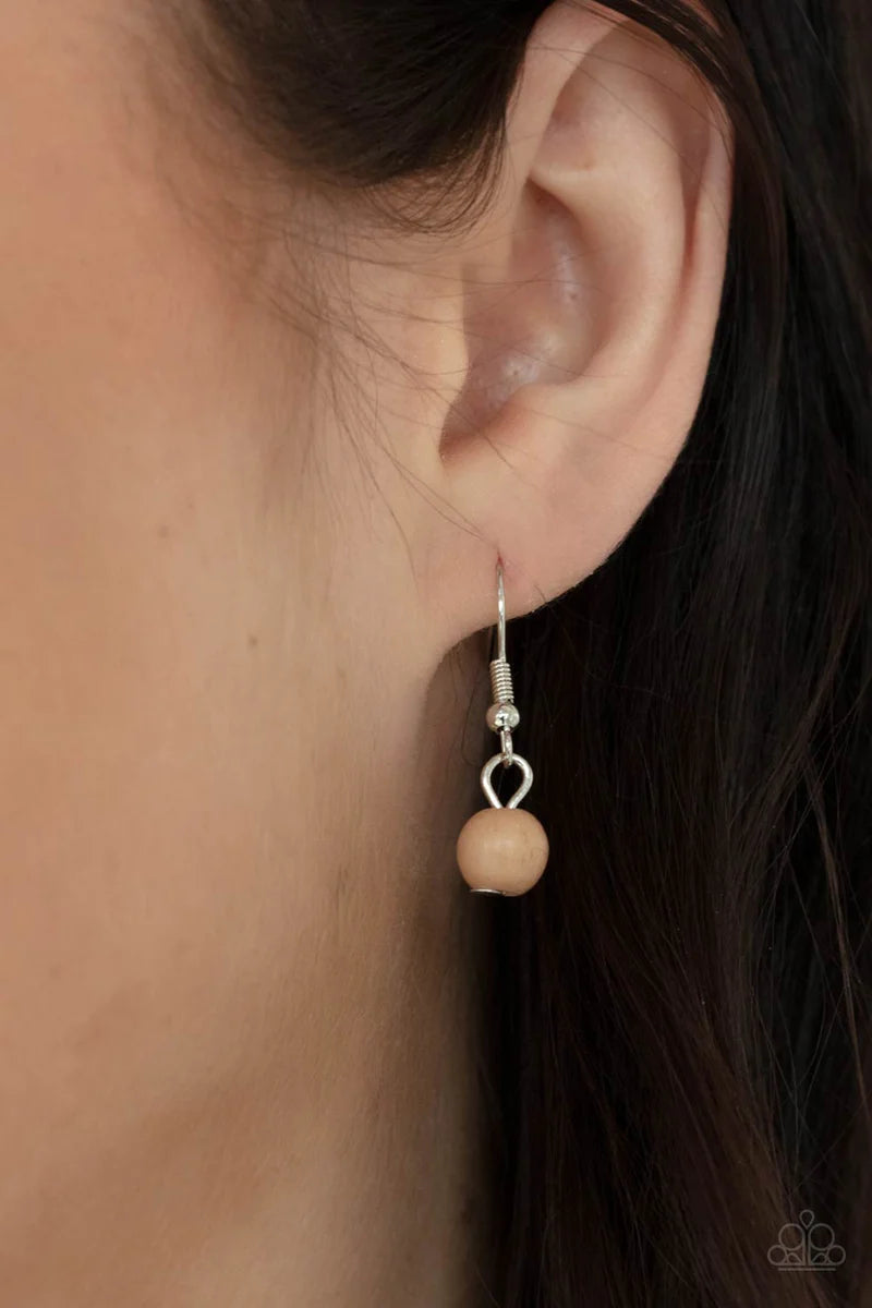 Paparazzi Accessories Naturally Essential - Brown A dainty collection of Desert Mist stones and rustic wooden beads connect into an earthy chain across the chest. Featuring sleek silver frames, oval Desert Mist stones and a rectangular wooden frame connec