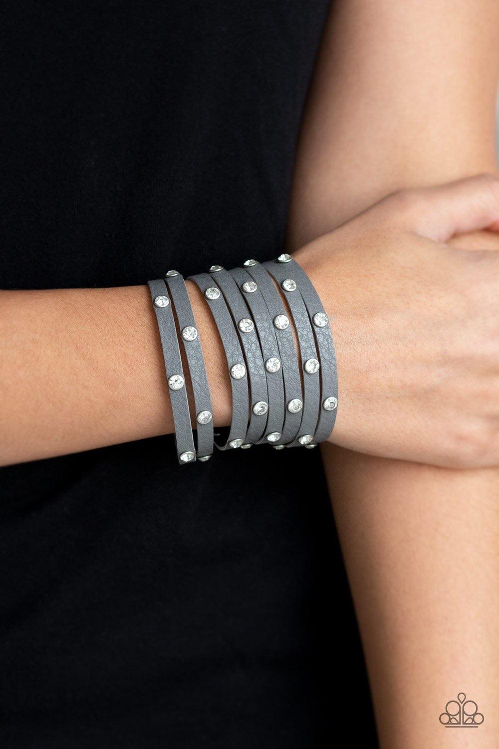 Paparazzi Accessories Sass Squad - Silver A thick gray leather band has been spliced into numerous gray strands. Featuring sleek silver frames, glittery white rhinestones are sprinkled across the leather bands for a sassy finish. Features an adjustable sn