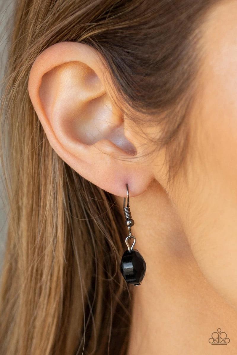 Paparazzi Accessories Duchess Dazzle - Black A collection of black rhinestone gems and abstract gunmetal rings trickle along a classic gunmetal chain across the chest for a refined flair. Features an adjustable clasp closure. Sold as one individual neckla