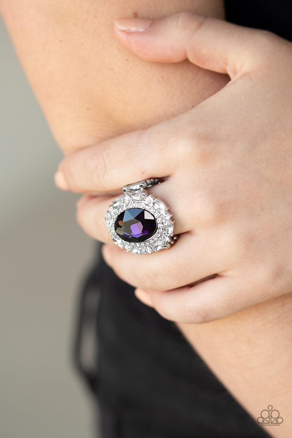 Paparazzi Accessories Show Glam - Purple An oversized oval purple gem is pressed into the center of a round silver frame encrusted in mismatched white rhinestones for a glamorous look. Features a stretchy band for a flexible fit. Jewelry