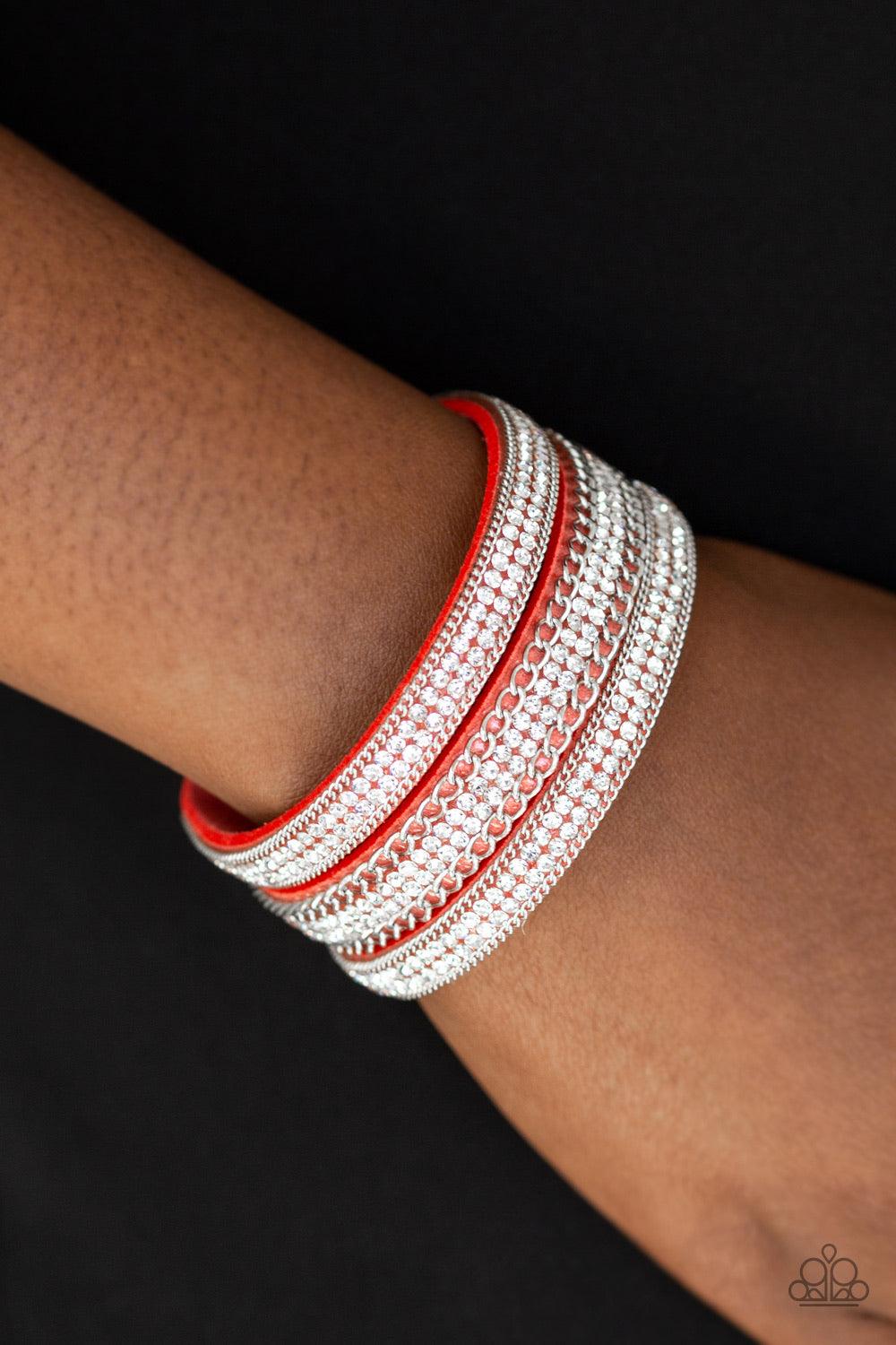 Paparazzi Accessories Dangerously Drama Queen - Orange Rows of shimmery silver chains and glassy white rhinestones are encrusted along a Blooming Dahlia suede band. The glittery band has been spliced into three strands, creating row after row of blinding