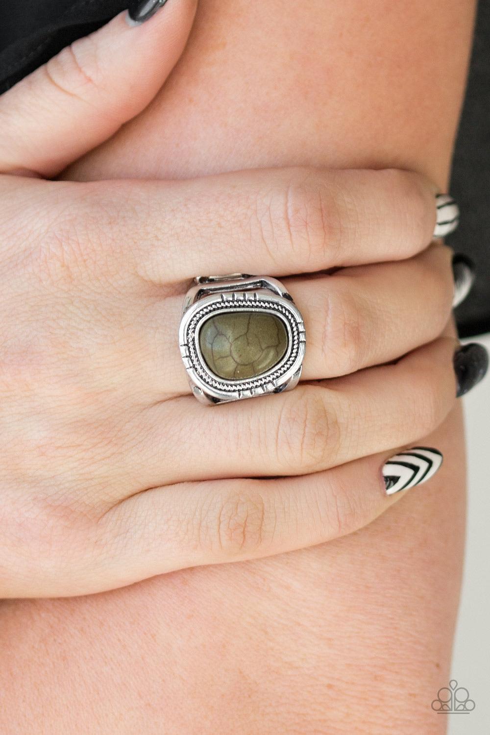 Paparazzi Accessories Out On The Range - Green An earthy Military Olive stone is pressed into an asymmetrical silver frame radiating with tactile textures for a seasonal look. Features a stretchy band for a flexible fit. Sold as one individual ring. Jewel