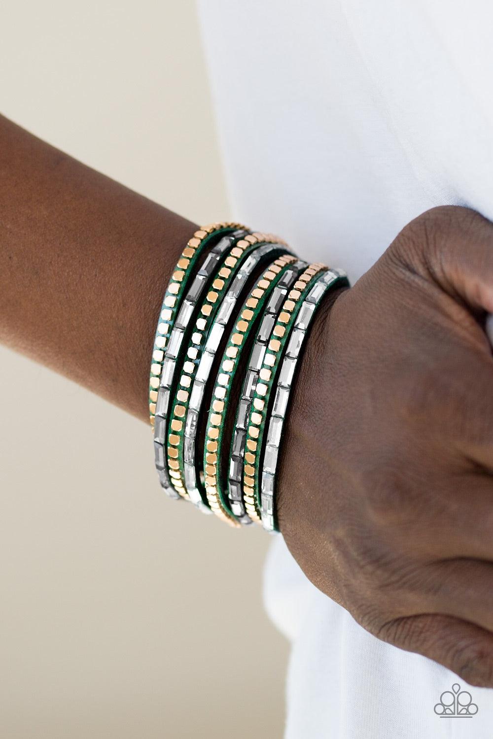 Paparazzi Accessories This Time With Attitude - Green Smoky and white emerald cut rhinestones and flat gold cube beads are encrusted along strands of green suede for a sassy look. The elongated band double wraps around the wrist for a fierce one-of-a-kind