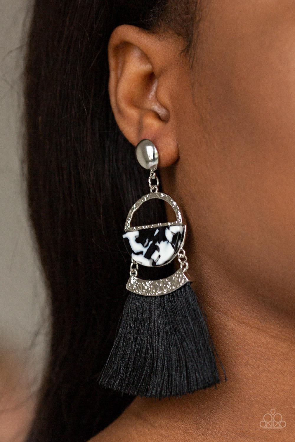 Paparazzi Accessories Tassel Trot - Black A shimmery silver stud links with a hammered silver frame featuring a faux marble acrylic accent. Featuring a hammered silver fitting, a shiny black threaded tassel attaches to the bottom of the retro lure for a f