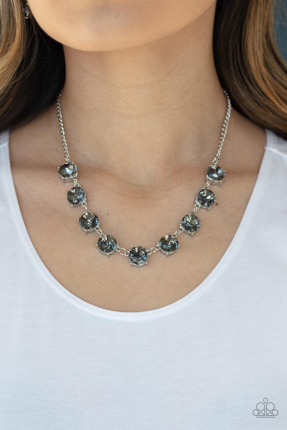 Paparazzi Accessories Iridescent Icing - Silver Featuring sleek silver fittings, a collection of oversized smoky rhinestones link below the collar for an icy look. Features an adjustable clasp closure. Jewelry