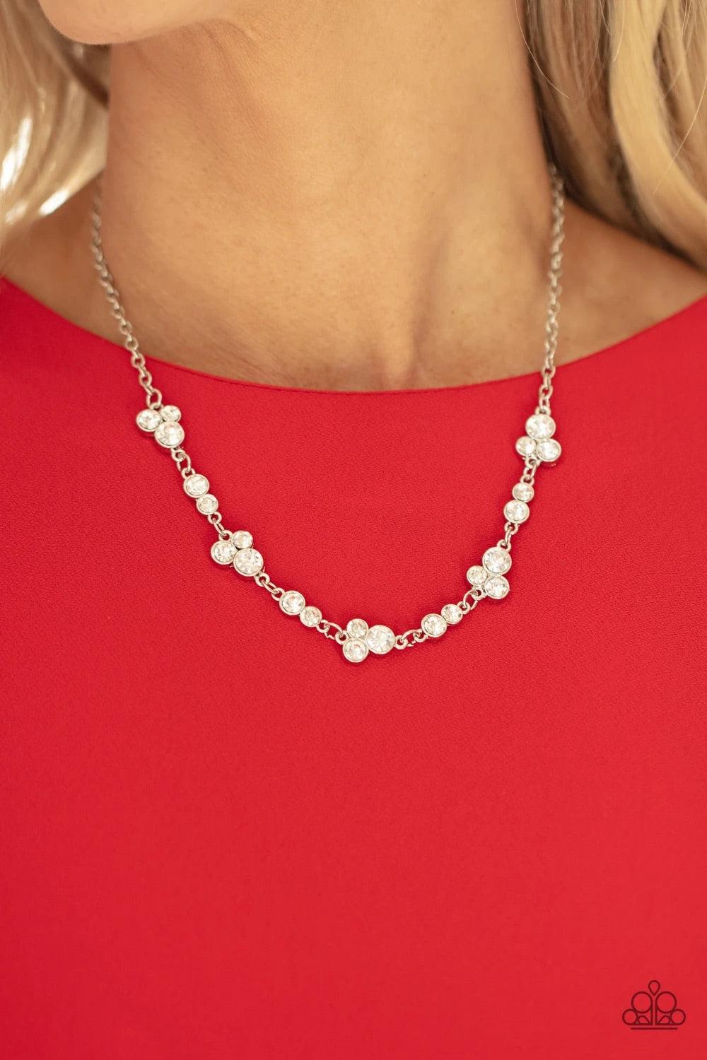 Paparazzi Accessories Gorgeously Glistening - White Encased in sleek silver frames, dainty pairs and trios of glittery white rhinestones delicately link into a timeless display below the collar. Features an adjustable clasp closure. Sold as one individual