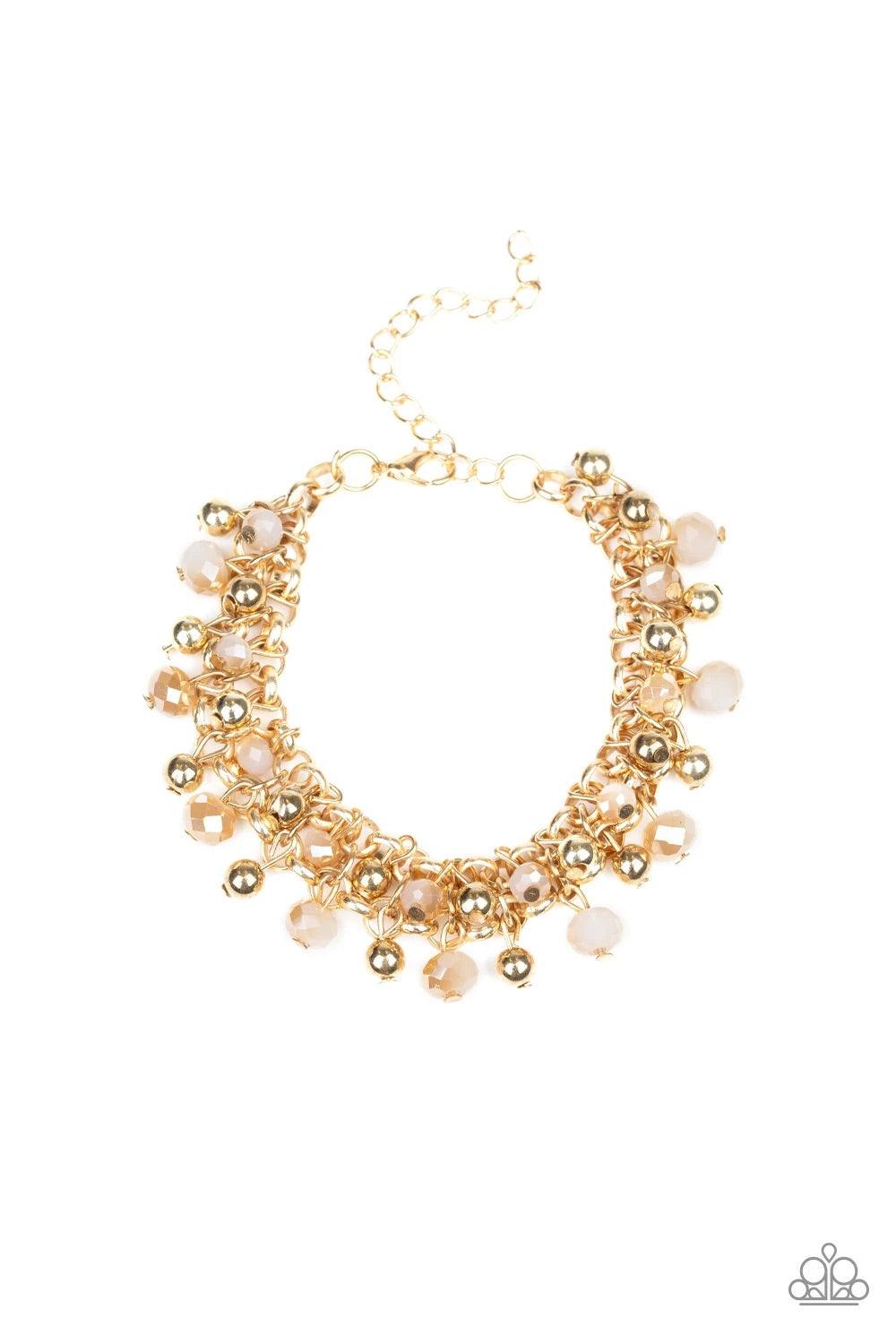 Paparazzi Accessories Just For The FUND Of It! - Gold Dipped into a golden metallic shimmer, faceted white beads and classic gold beads swing from interlocking gold chains, creating a refined fringe around the wrist. Features an adjustable clasp closure.