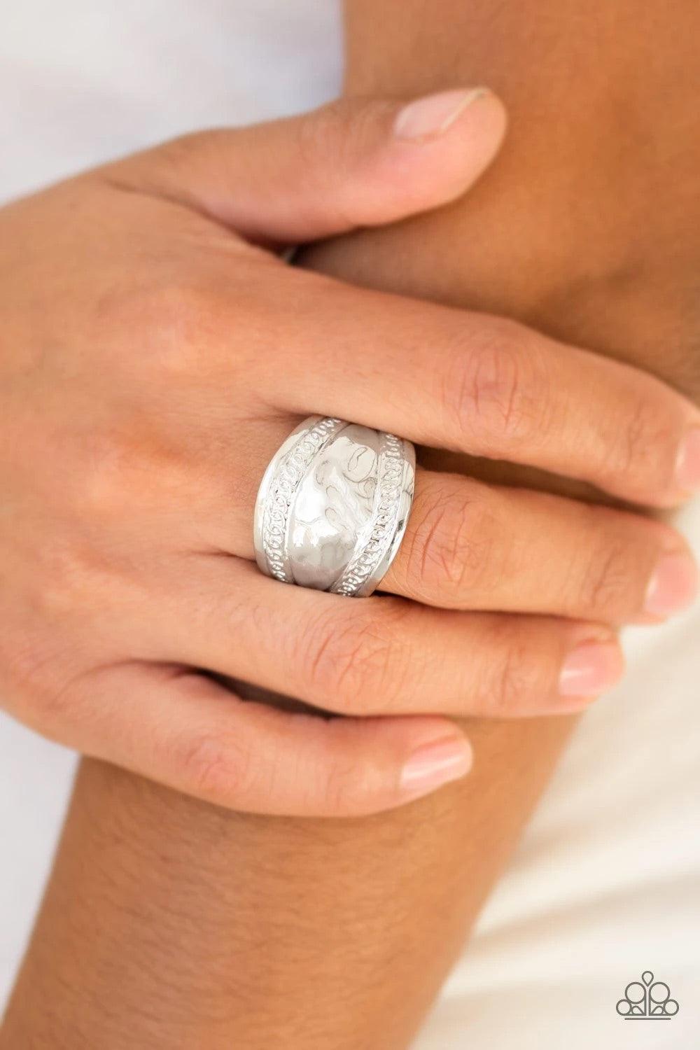 Paparazzi Accessories Sunset Groove - Silver Ribbons of circular texture are embossed along the borders of a hammered silver band for an edgy look. Features a stretchy band for a flexible fit. Sold as one individual ring. Jewelry