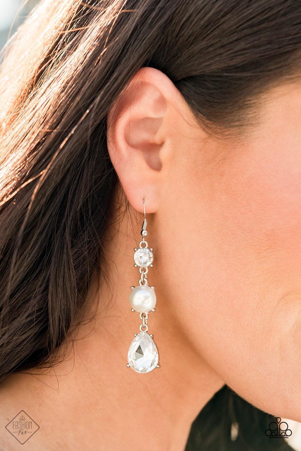 Paparazzi Accessories Unpredictable Shimmer ~White An oversized white teardrop gem swings from the bottom of a stacked pearly white bead and classic white rhinestone, creating a timeless lure. Earring attaches to a standard fishhook fitting. Sold as one p