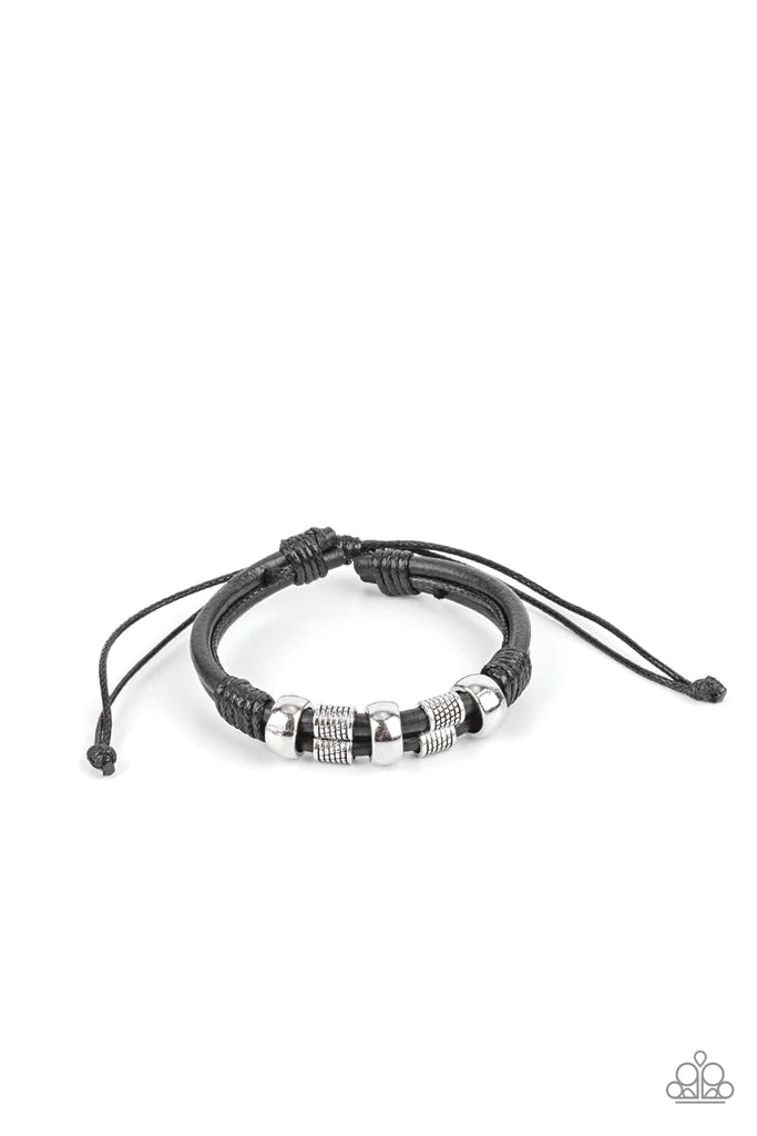 Paparazzi Accessories Urban Cattle Drive - Black Shiny and textured silver cylindrical accents slide along a double layer of thick black leather cording. Glossy thread wrangles the ends together creating a rustic finish as it wraps around the wrist. Featu