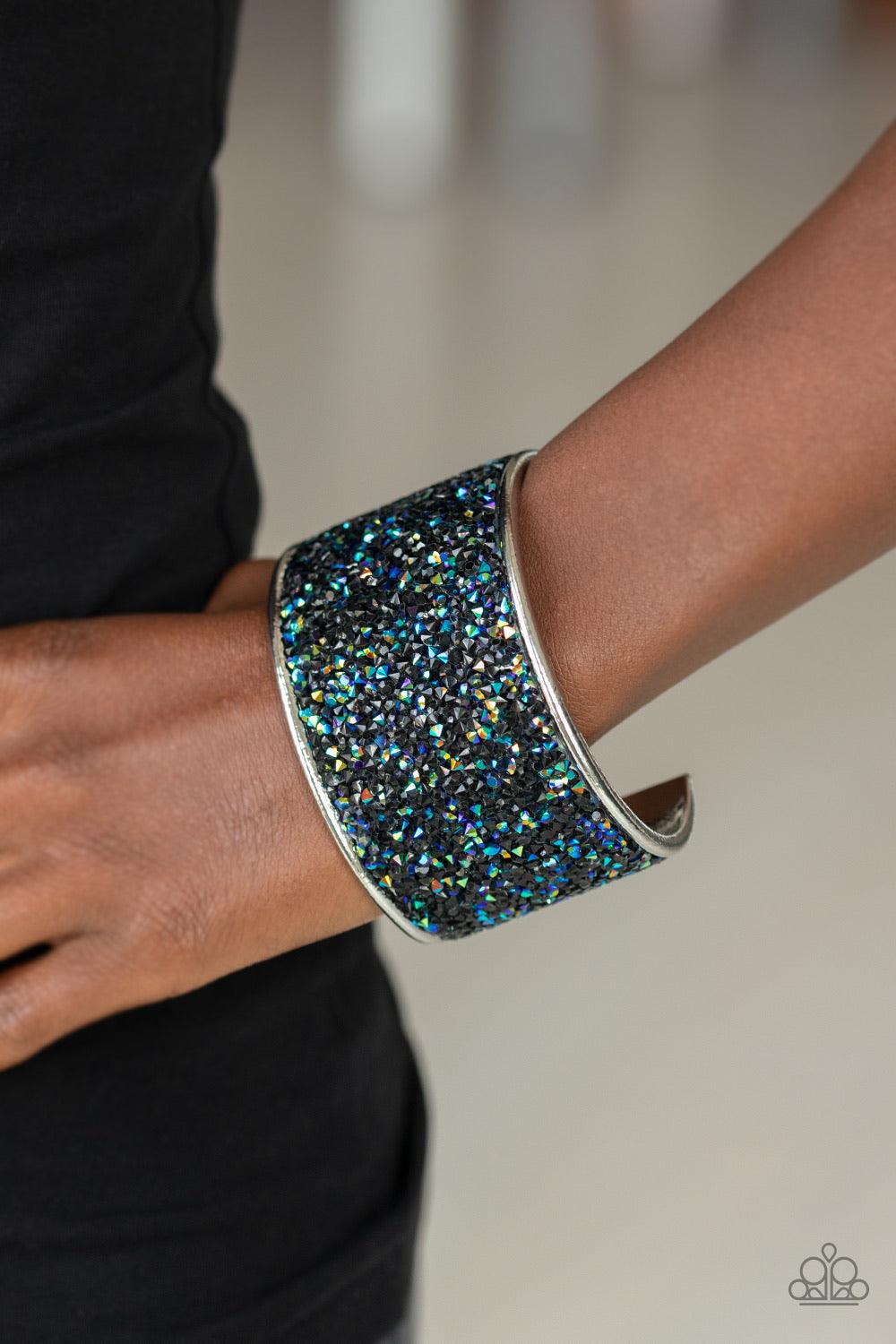 Paparazzi Accessories Stellar Radiance - Black A brilliant collision of glassy black and metallic oil spill rhinestones are encrusted across the front of a thick silver cuff, creating a stellar sparkle. Sold as one individual bracelet. Jewelry