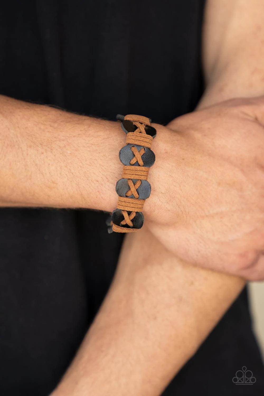 Paparazzi Accessories Macho Maverick - Multi Light brown suede cording is threaded in a crisscross pattern along the front of a wavy brown suede band. Additional brown cording wraps across the scalloped band in intervals creating a rustic handmade look. F