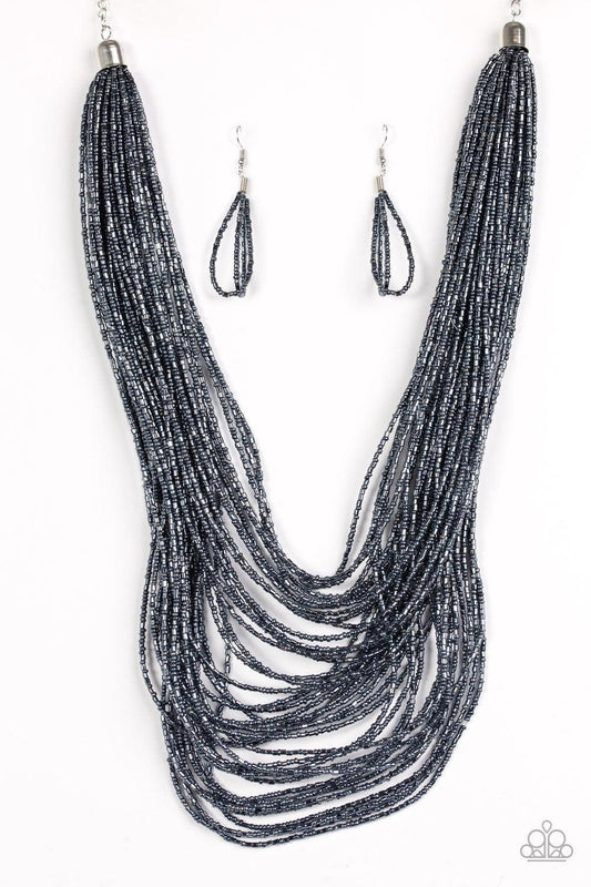 Paparazzi Accessories Ice Storm - Blue Brushed in an icy metallic shimmer, countless strands of blue seed beads drape across the chest in a bold fashion. Featuring a collision of shapes and shimmer, the glittery strands connect to two large silver accents