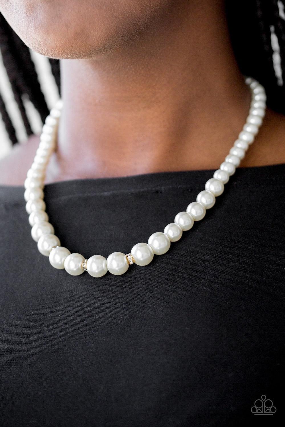 Paparazzi Accessories Royal Romance - Gold Gradually increasing in size near the center, a strand of luminescent white pearls falls just below the collar. White rhinestone encrusted rings are sprinkled along the center for a timeless finish. Features an a