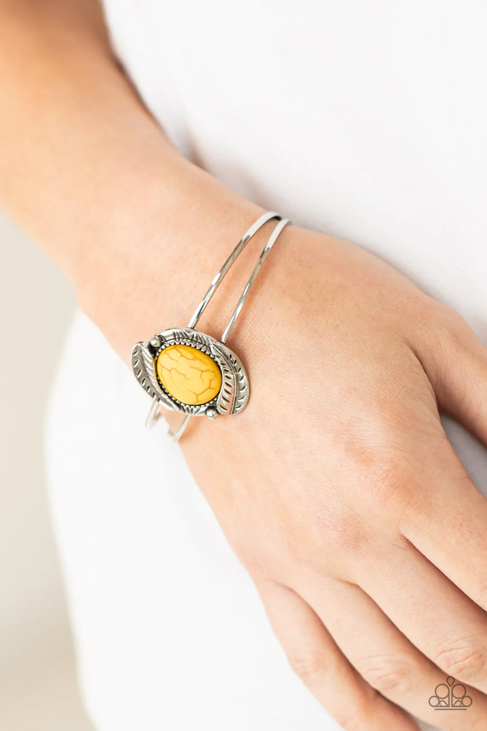 Paparazzi Accessories Living Off The BANDLANDS - Yellow Feathery silver frames are nestled around a sunny yellow stone center, creating a seasonal centerpiece atop a dainty silver cuff. Sold as one individual bracelet.