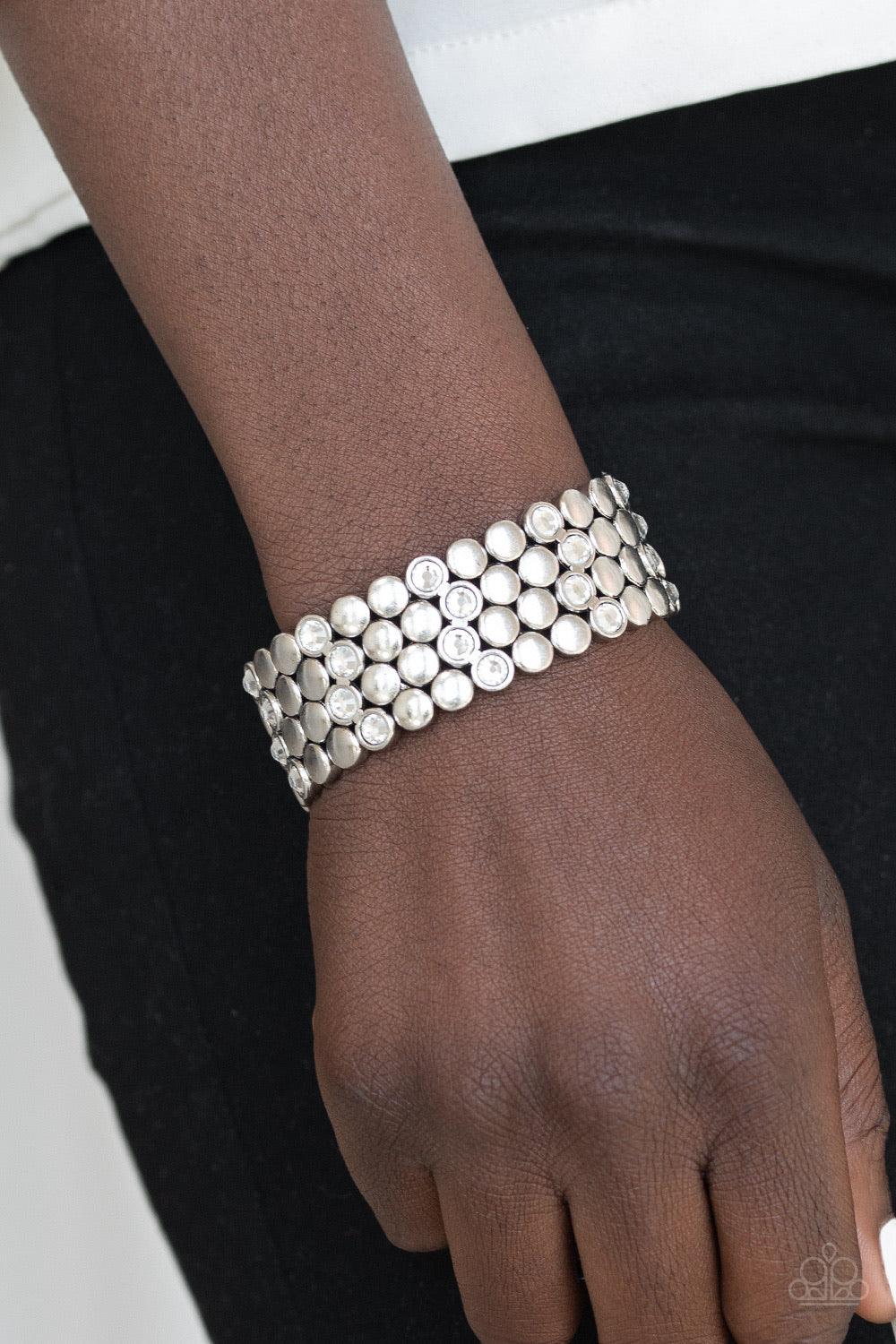 Paparazzi Accessories Scattered Starlight - White A collection of frames featuring flat silver studs and glittery white rhinestones are threaded along a stretchy band, scattering sparkle across the wrist. Jewelry