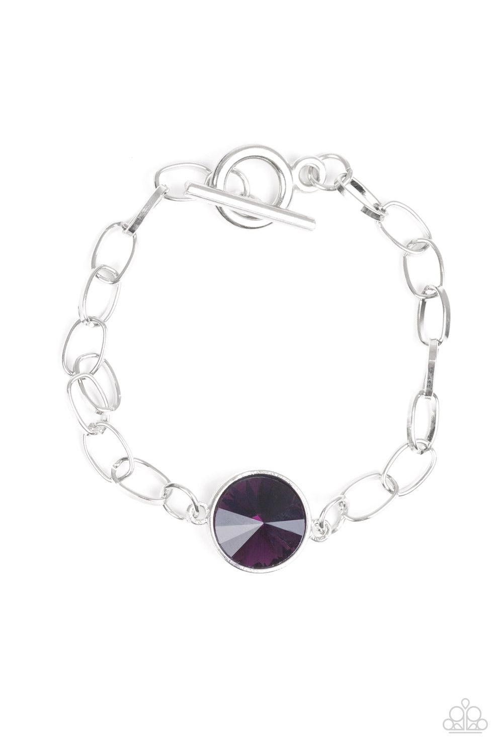 Paparazzi Accessories All Aglitter - Purple A dramatic purple gem attaches to a shiny silver chain, creating a blinding centerpiece atop the wrist. Features a toggle closure. Jewelry