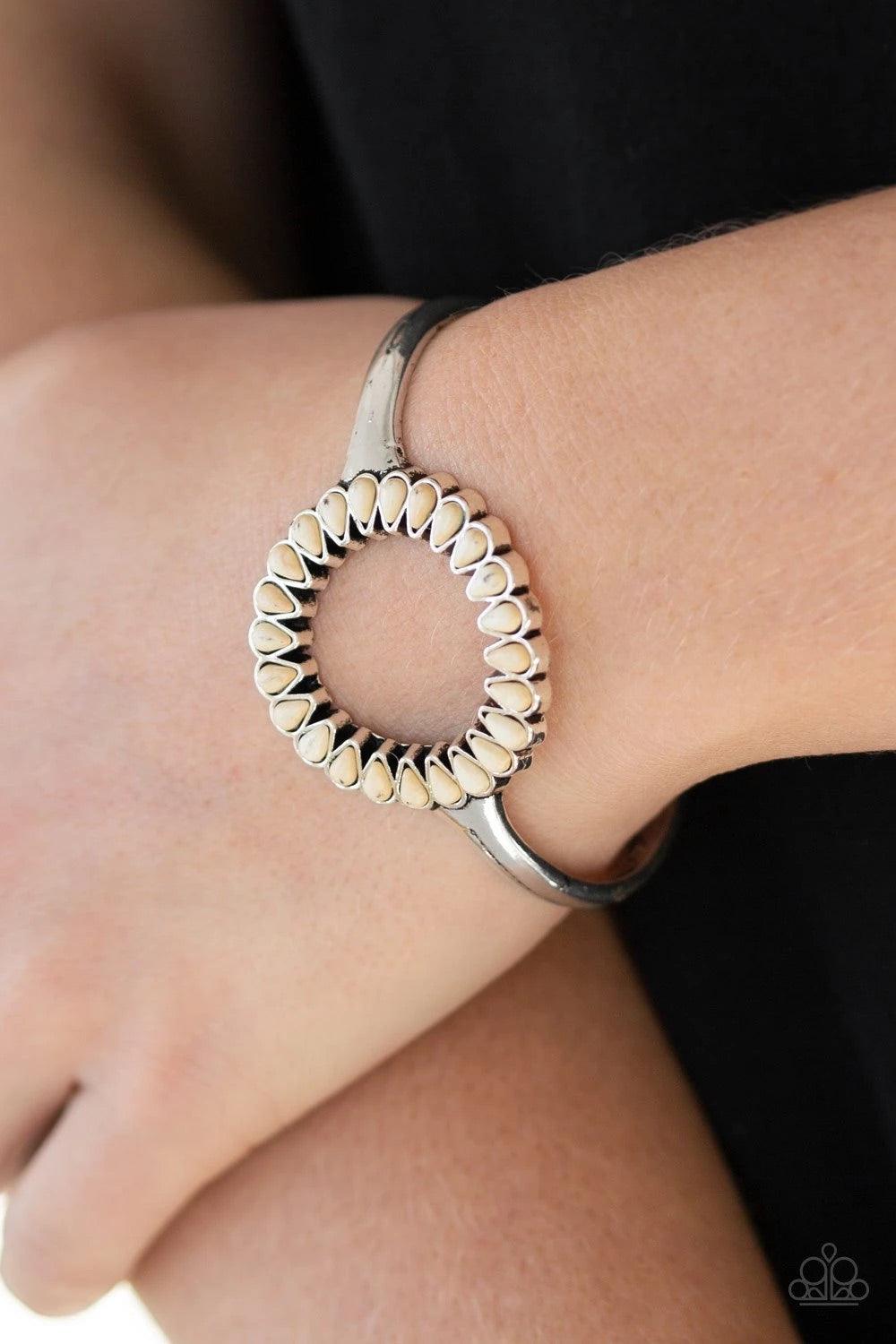 Paparazzi Accessories Divinely Desert - White Chiseled into tranquil teardrops, refreshing white stones spin around the center of an antiqued silver cuff for a seasonal look. Sold as one individual bracelet. Jewelry