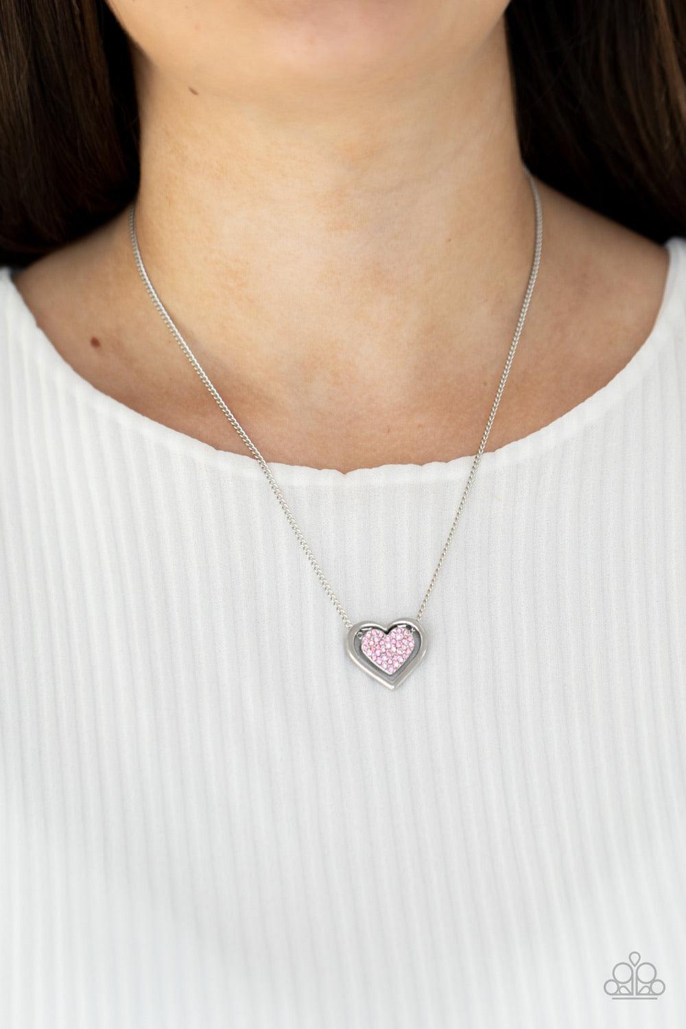 Paparazzi Accessories Game, Set, MATCHMAKER - Pink Bordered in a shiny silver frame, a pink rhinestone encrusted silver heart is suspended below the collar for a gorgeously romantic look. Features an adjustable clasp closure. Sold as one individual neckla