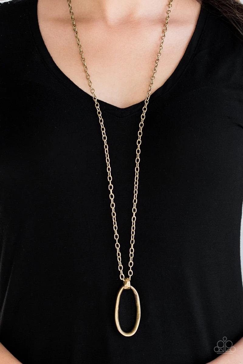 Paparazzi Accessories Grit Girl - Brass Delicately hammered in a gritty antiqued finish, a bold asymmetrical brass ring swings from the bottom of a lengthened brass chain for an industrial look. Features an adjustable clasp closure. Sold as one individual