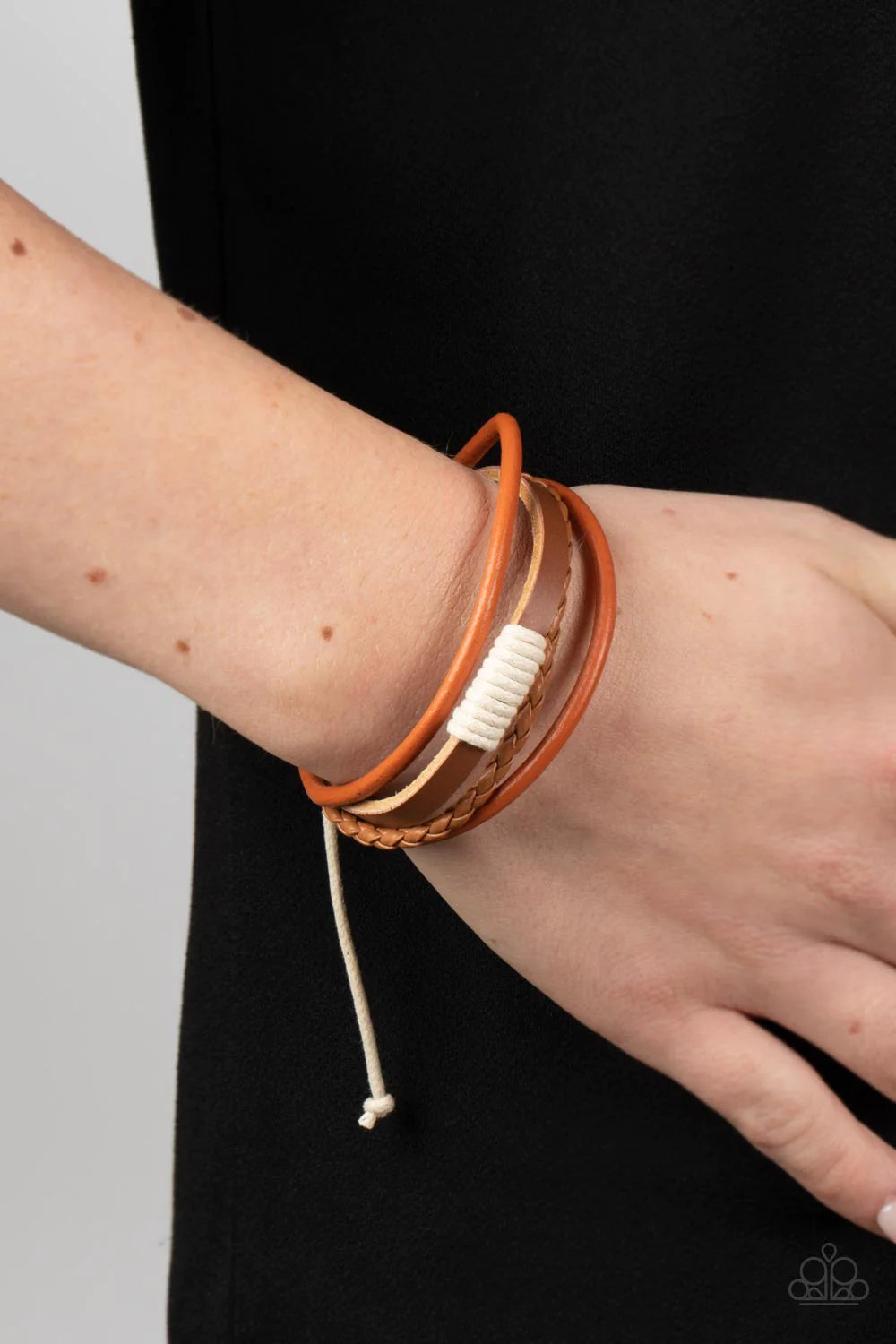 Paparazzi Accessories Trail Scout - Orange Knotted together with white cording, mismatched orange and brown leather bands layer around the wrist for an adventurous pop of color. Features an adjustable sliding knot closure. Sold as one individual bracelet.