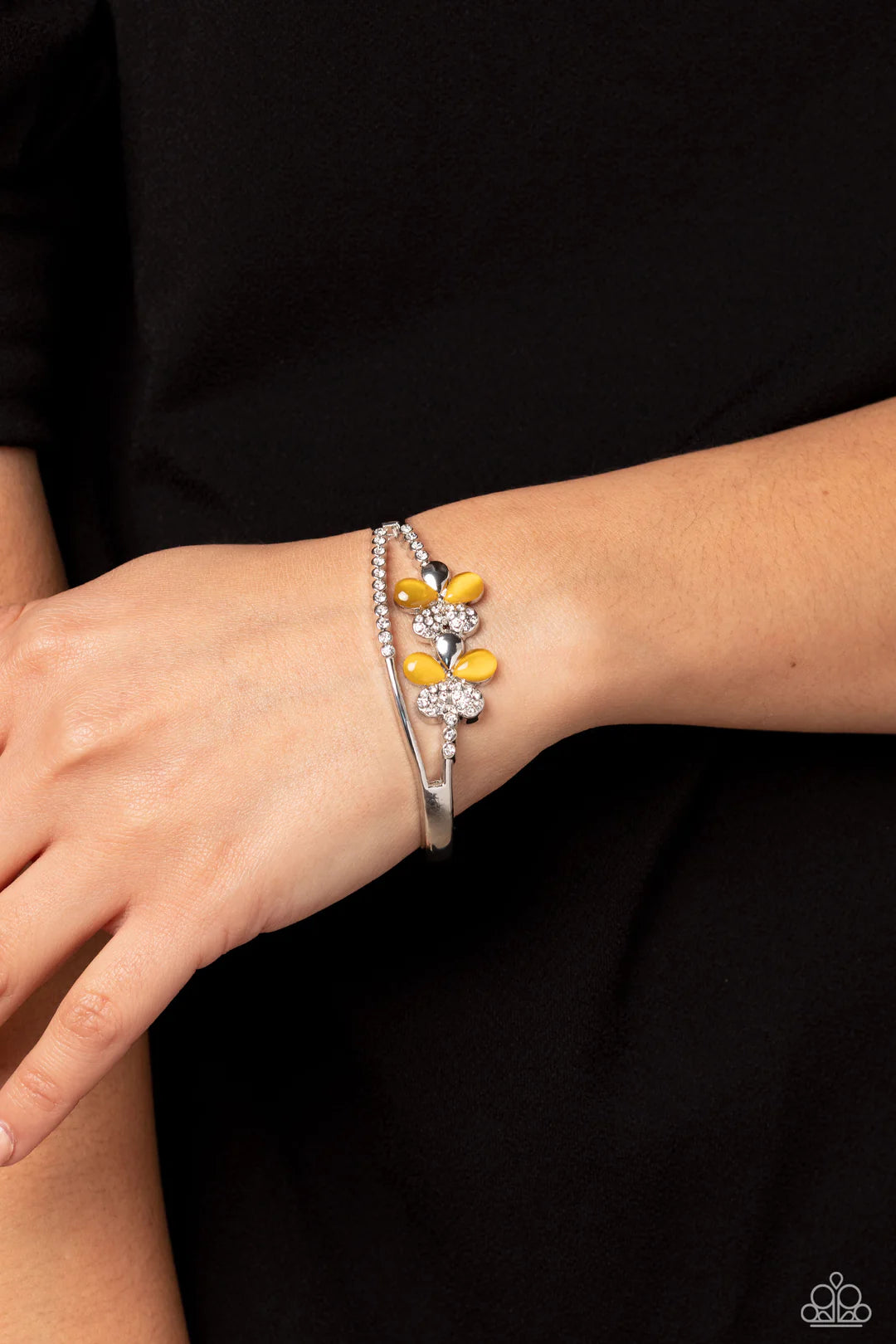 Paparazzi Accessories Broadway Stage - Yellow Splitting off from a high-sheen silver cuff, silver scalloped fittings featuring tiny white rhinestones create an airy opening at the center of the wrist. Infused along the uppermost scalloped fitting, two sid