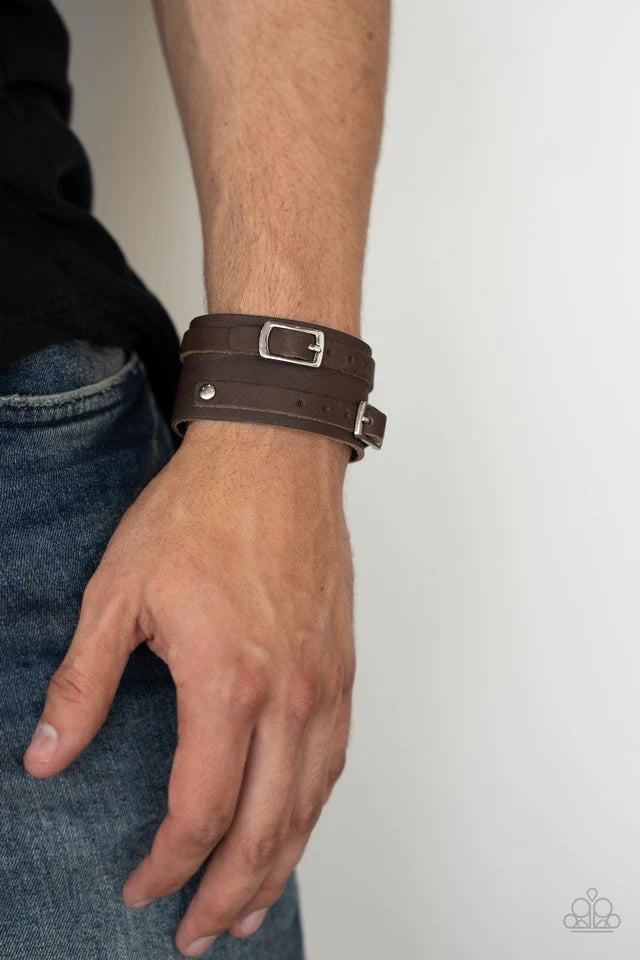 Paparazzi Accessories Bronco Bustin’ Buckles - Brown A pair of brown leather buckles are buckled in place across the front of a rustic brown leather band for a seasonal look. Features an adjustable snap closure Jewelry