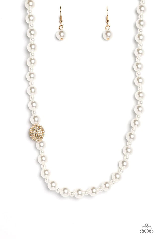 Paparazzi Accessories Countess Chic - Gold Strung along the entirety of an invisible wire, classic white pearls in varying sizes coalesce down the neckline for a refined finish. Adding to the elegant design, a sparkly white rhinestone-encrusted gold ornam