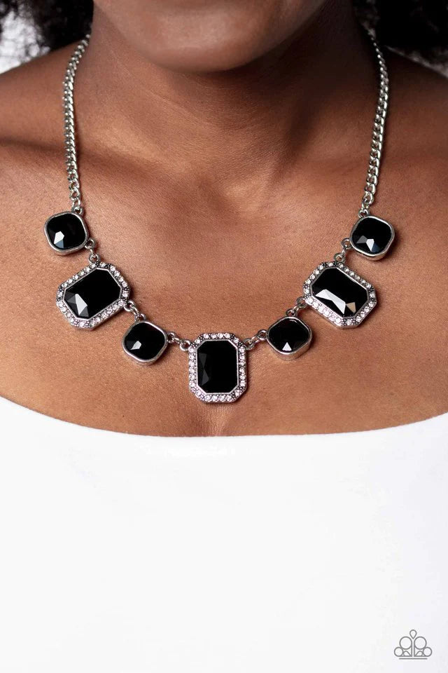Paparazzi Accessories Royal Rumble - Black Dazzling gems, in both round and emerald-cuts, fall along the collar in an alternating pattern. Each gem is splashed in a dauntless, jet black hue amplifying its impact, while the emerald-cut gems showcase some g