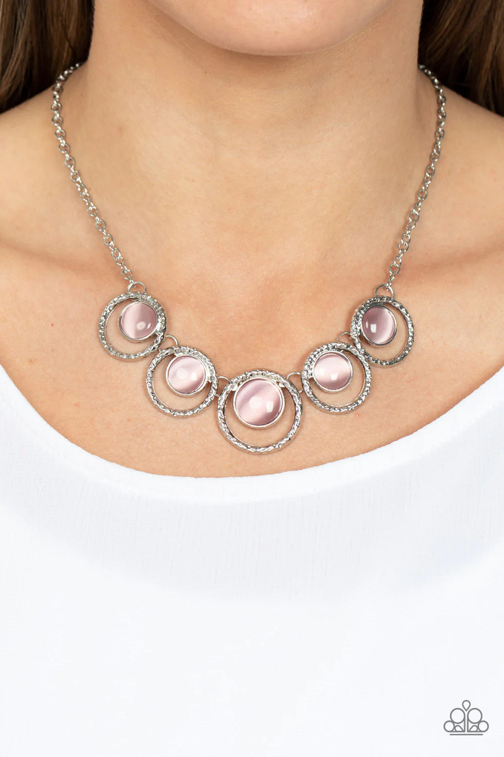 Paparazzi Accessories Elliptical Enchantment - Pink Glassy pink cat's eye stones seemingly float inside hammered silver hoops that delicately link below the collar, resulting in an ethereal pop of color. Features an adjustable clasp closure. Sold as one i