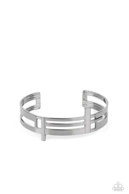 Paparazzi Accessories Barred Lines - Black Two vertical cutouts run through a collection of lined abstract details on a bold airy gunmetal cuff that has been hammered with light-catching texture. Jewelry