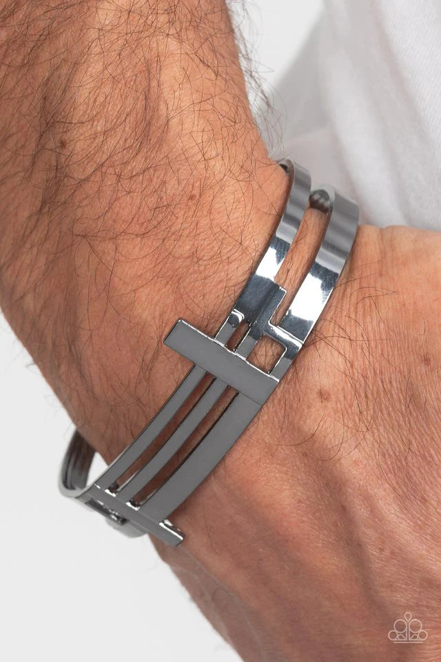 Paparazzi Accessories Barred Lines - Black Two vertical cutouts run through a collection of lined abstract details on a bold airy gunmetal cuff that has been hammered with light-catching texture. Jewelry