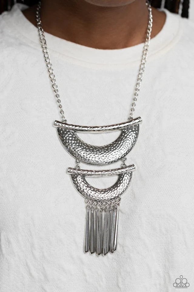 Paparazzi Accessories Fringe Festival - Silver Hammered in textured detail, two oversized silver half moon plates connect down the chest, creating a fiercely stacked pendant. Sleek silver rods swing from the bottom of the lowermost plate, creating an eye-