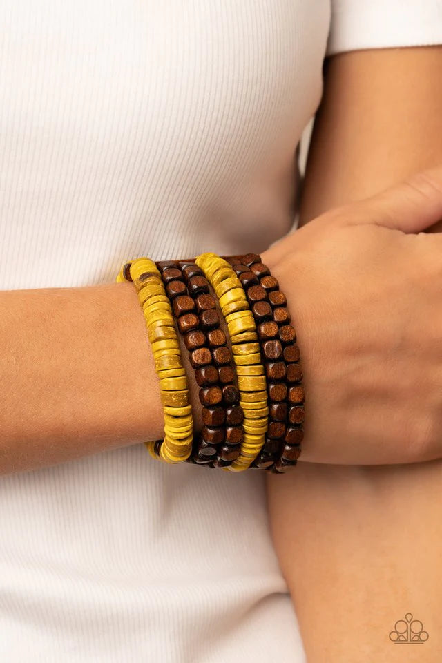 Paparazzi Accessories Fiji Fiesta - Yellow Stretchy strands of brown wooden cube beads and distressed yellow wooden discs are held in place by rectangular wooden frames, resulting in an earthy centerpiece around the wrist. Jewelry