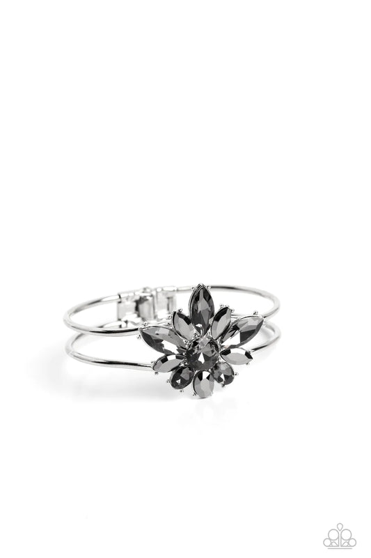 Paparazzi Accessories Chic Corsage - Silver Varying sizes of oval and marquise-cut gems in hematite and smoky shades bloom around a round-brilliant cut center in a similar smoky hue. The dazzling collection of sparkly petals coalesces into a stunning flor