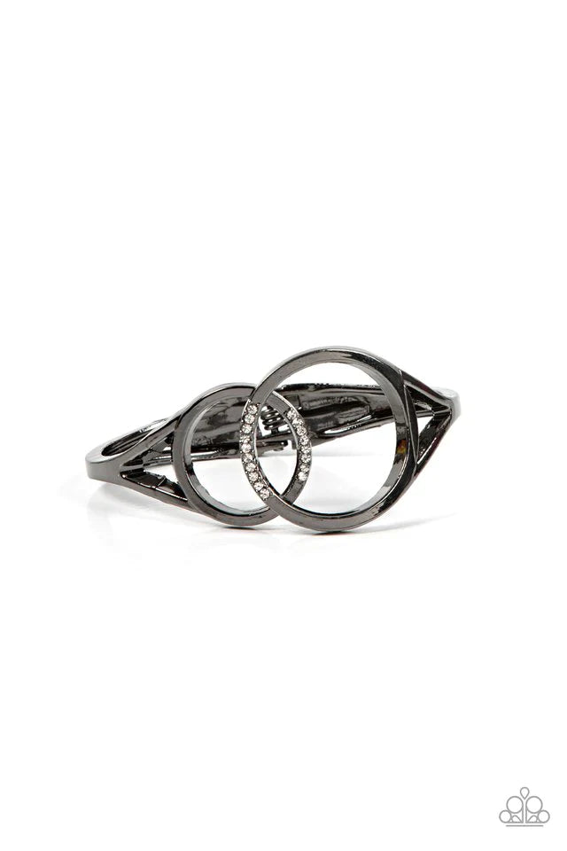 Paparazzi Accessories Scope of Experience - Black Encrusted in sections of glassy white rhinestones, two oversized gunmetal rings delicately overlap across the center of the wrist, resulting in a timeless bangle-like bracelet around the wrist. Features a