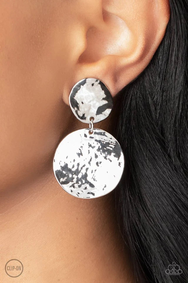 Paparazzi Accessories Rush Hour - Silver *Clip-On Hammered with high-sheen texture, warped silver discs delicately link into a bold monochromatic statement piece. Earring attaches to a standard clip-on fitting. Sold as one pair of clip-on earrings. Jewelr
