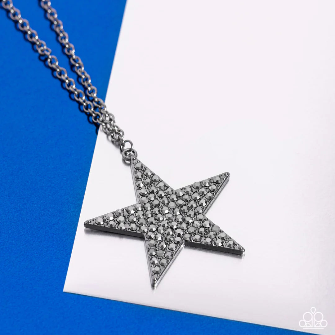 Paparazzi Accessories Rock Star Sparkle - Black The front of an oversized gunmetal star is encrusted in smoldering hematite rhinestones, resulting in a stellar pendant at the bottom of a lengthened gunmetal chain. Features an adjustable clasp closure. Sol