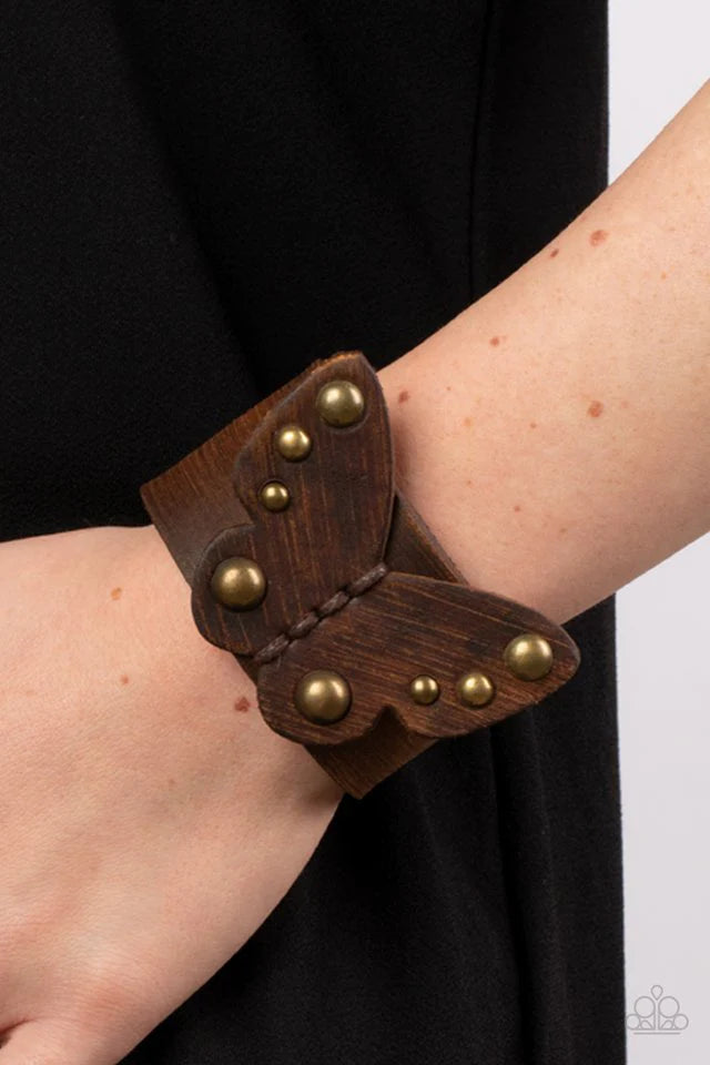 Paparazzi Accessories Butterfly Farm - Brass Dotted with antiqued brass studs, a distressed leather butterfly is studded in place across the center of a distressed brown leather band for a rustic flair. Features an adjustable snap closure. Jewelry