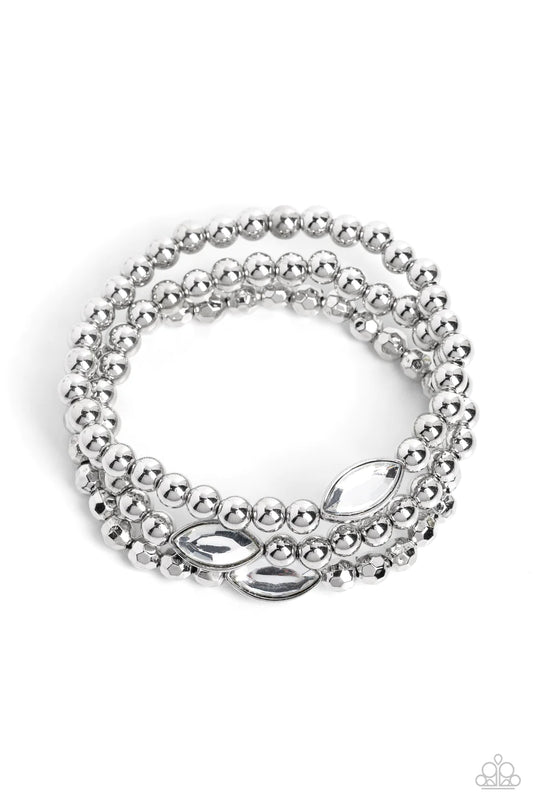 Paparazzi Accessories Twinkling Team - White Featured in the center of a faceted and smooth silver beaded display, a dazzling white, marquise-cut gem pressed in a sleek silver frame wraps around the wrist on elastic stretchy bands for a classy statement.