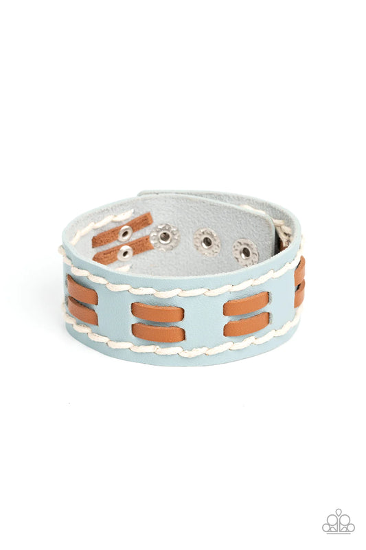 Paparazzi Accessories In the FRONTIER Running - Blue Flanked with white stitched rows, two rows of brown leather laces are threaded through the center of a blue leather band for a rustic pop of color around the wrist. Features an adjustable snap closure.