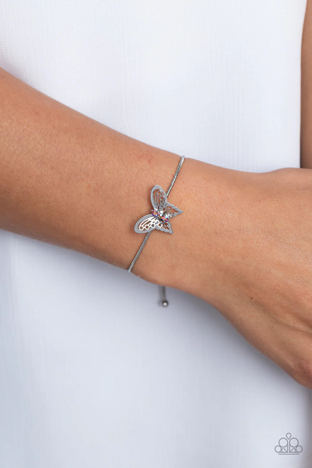 Paparazzi Accessories Wings of Wonder - Pink A deceptively simple silver butterfly charm glides along a silver snake chain for a whimsical flair along the wrist. Dainty, pink rhinestones, brushed in a UV shimmer, encrust along the butterfly's body, creati