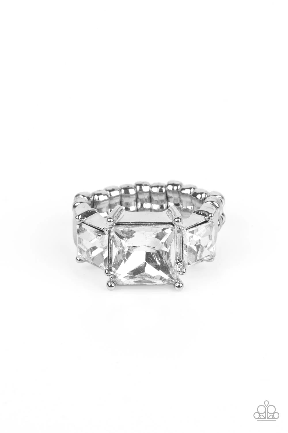 Paparazzi Accessories Treasured Twinkle - White Featuring regal princess cuts, three brilliant white rhinestones sparkle inside pronged silver fittings atop the finger in a dramatic finish. Features a dainty stretchy band for a flexible fit. Sold as one i