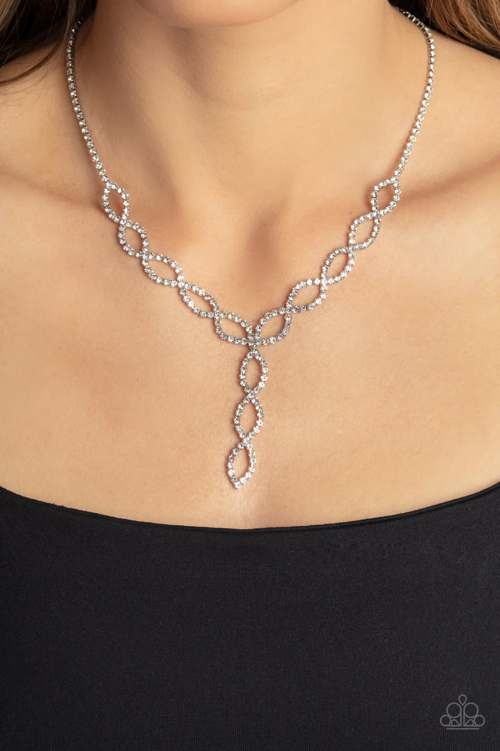 Paparazzi Accessories Infinitely Icy - White Strands of glassy white rhinestones delicately loop into interlocking infinities below the collar, drizzling into an icy extended pendant for a statement-making finish. Features an adjustable clasp closure. Sol