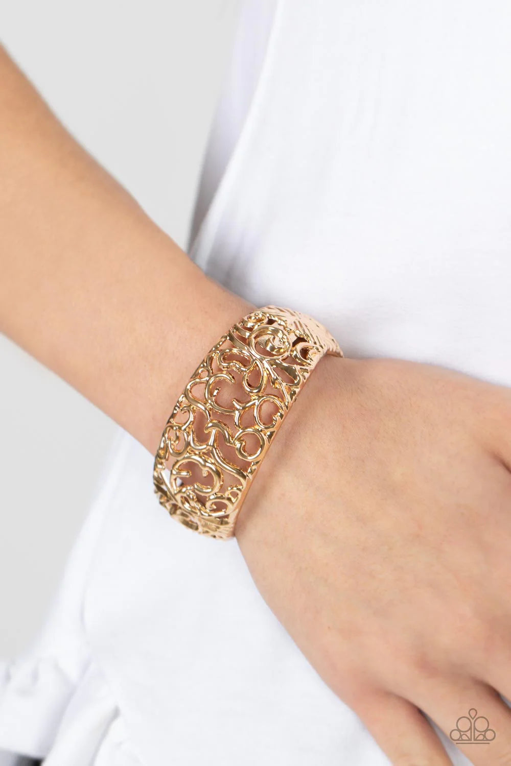 Paparazzi Accessories Courtyard Couture - Gold Glistening gold vine-like filigree enchantingly twines across the centers of two airy gold frames that delicately hinged into a bangle-like bracelet, resulting in a regal centerpiece. Features a hinged closur