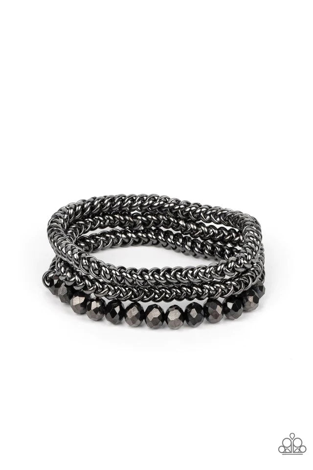 Paparazzi Accessories Gutsy and Glitzy - Black Threaded along stretchy bands, sections of hematite crystal-like beads and interlocking gunmetal chains layer around the wrist for a dash of glitzy grunge. Jewelry